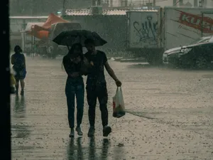 Tânăr cuplu mergând prin ploaie, sub umbrelă - Foto: Pexels/Nikita Korchagin